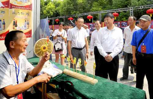 余學(xué)友察看“中國農(nóng)加工洽談會(huì)”非物質(zhì)文化遺產(chǎn)展展區(qū)